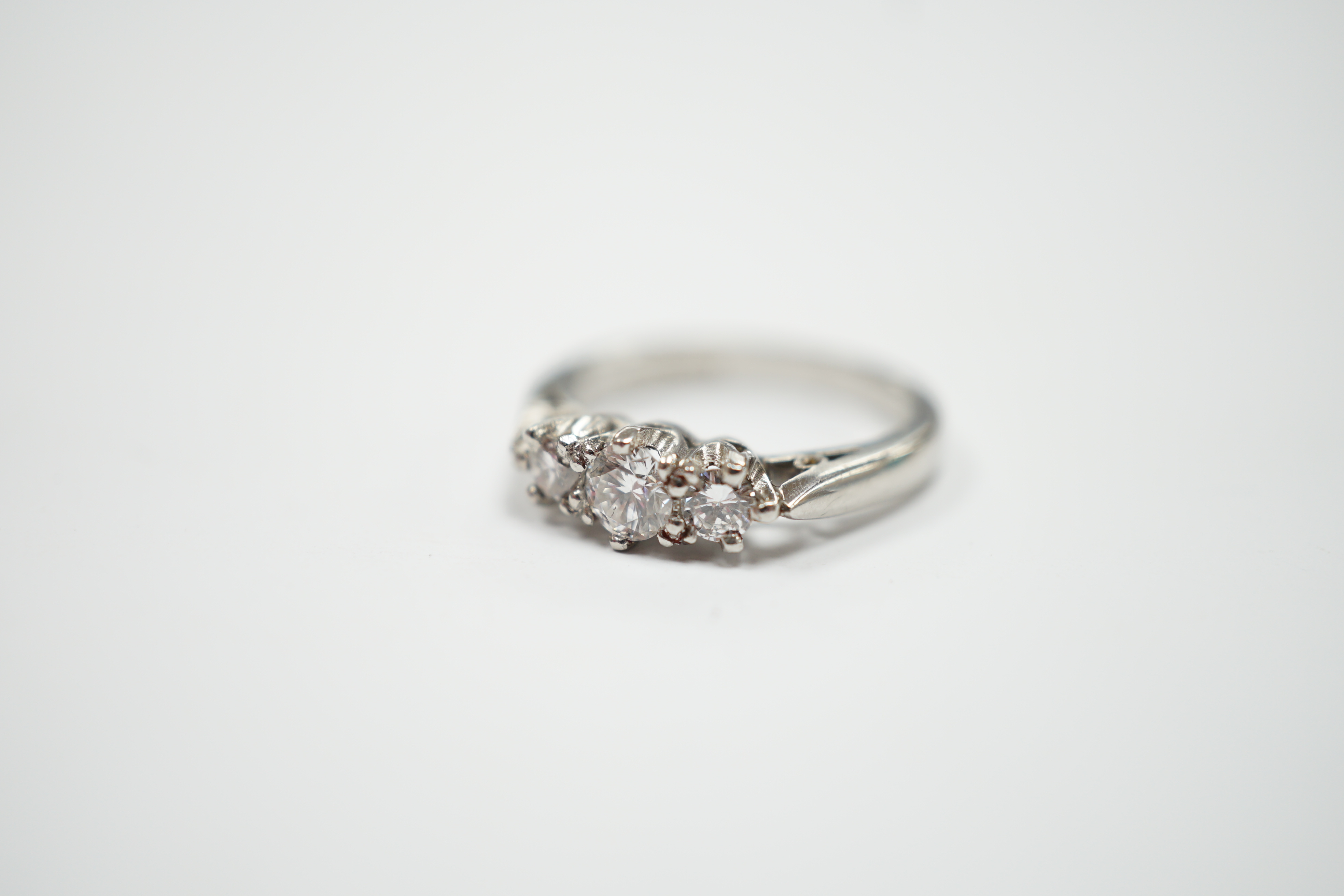 A modern platinum and three stone diamond set ring, size J, gross weight 4.6 grams.